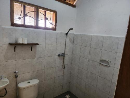 a bathroom with a toilet and a sink and a window at Serah's Homestay in Kuta Lombok