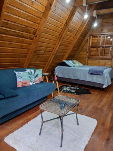 a living room with a couch and a table in a attic at Cabana Cipó in Passo Fundo