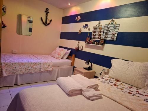 two beds in a room with blue and white stripes at Casa Lilia 10 minutos Aeropuerto Tocumen in Panama City