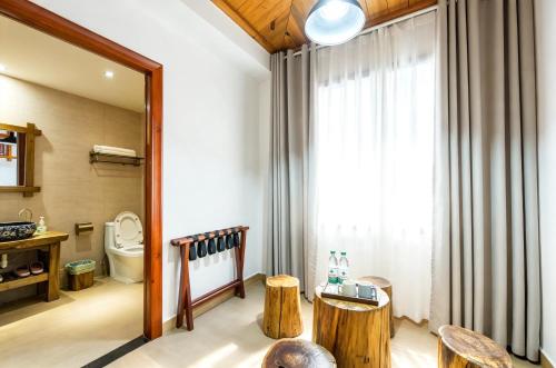 a bathroom with a toilet and a window at Windmoon Hillcourt Tianmen Vis Lodge in Zhangjiajie