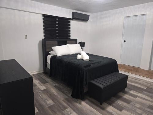 a bedroom with a bed with a teddy bear on it at Black House in Anasco