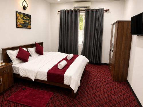 a bedroom with a bed and a window with curtains at Amore Beach Resort in Balapitiya