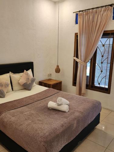 a bedroom with a bed with two towels on it at Serah's Homestay in Kuta Lombok