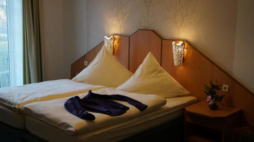 Una cama con dos albornoces azules. en Richzenhainer-Hof, en Waldheim