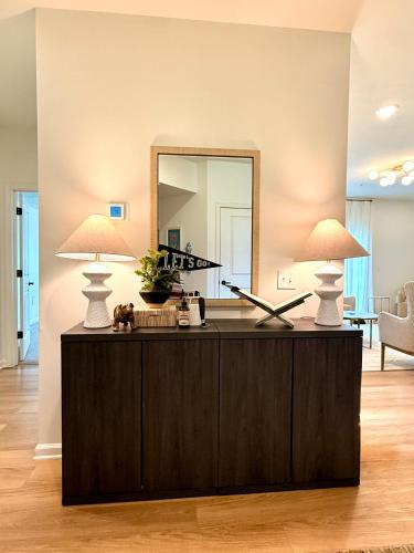 two lamps on top of a dresser with a mirror at StarkVilla - The Perfect Location! in Starkville