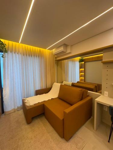 a living room with a couch and a bed in it at Studio Mandarim Campolim in Sorocaba