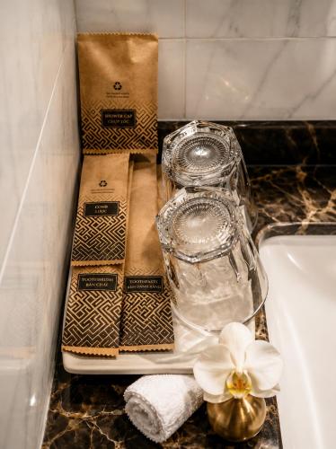a bathroom counter with a plate with glasses and a flower at Tam Coc Sylvani Homestay in Vũ Lâm