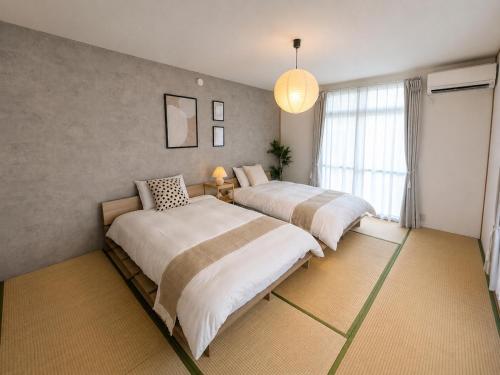 a bedroom with two beds and a window at Forest Agata in Matsumoto