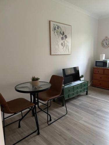 a room with a table and a desk with a laptop at Guinevere 2 in Myrtleford
