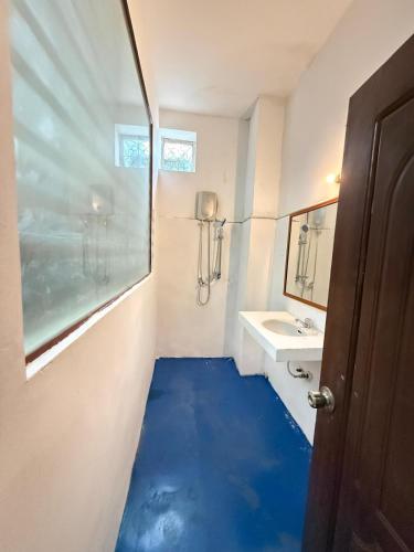a bathroom with a blue floor in front of a sink at White Castle in Siem Reap