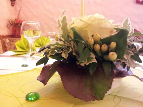 a flower arrangement on a table with a wine glass at Richzenhainer-Hof in Waldheim