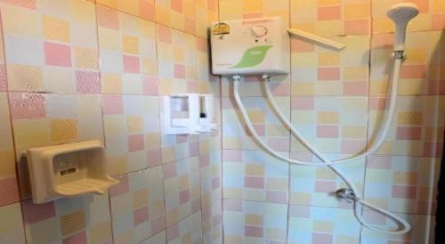 a shower in a bathroom with a hose attached to the wall at Tai Asean House in Ban Kham Kling