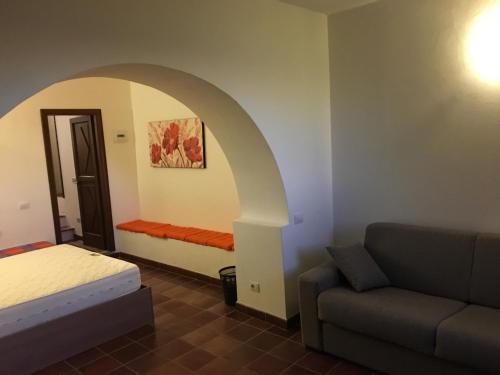 um quarto com uma cama e um sofá num quarto em Montemarcello Holiday Home em Ameglia