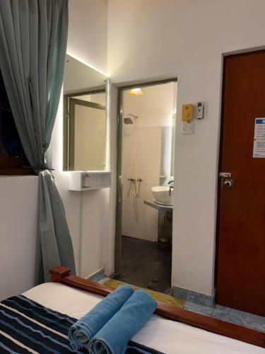a bathroom with a bed and a sink and a mirror at Natures Bliss Holidays in Ja-Ela