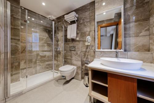伊斯坦堡的住宿－尼桑特酒店，一间带水槽、淋浴和卫生间的浴室