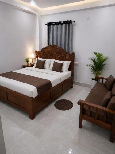 a bedroom with a large wooden bed and a couch at PRANSHI HOMe STAY in Deoghar