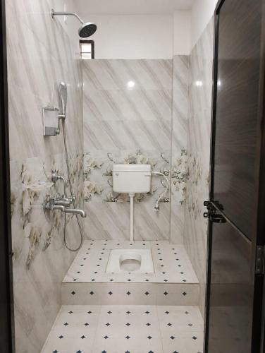 a white bathroom with a toilet and a shower at PRANSHI HOMe STAY in Deoghar