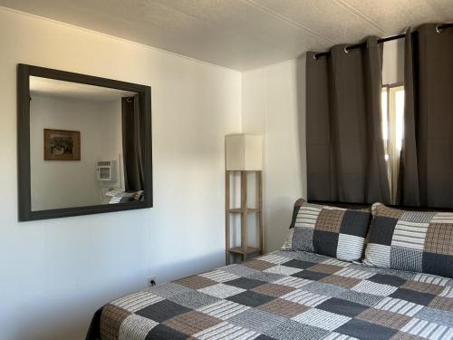 a bedroom with a bed and a mirror on the wall at Sunsets and City Lights 3BD 2Bath in Miramonte
