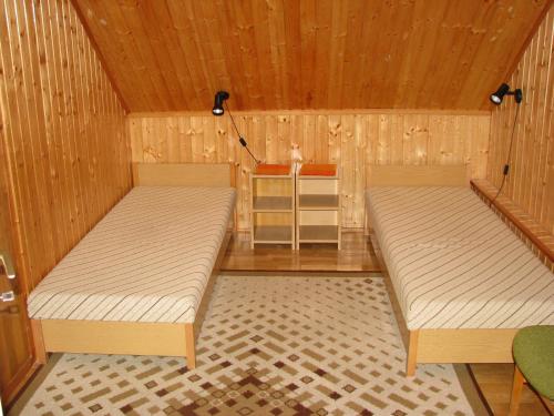 レーヴフュロップにあるOttó Nyaralóのベッド2台 木製の壁の部屋
