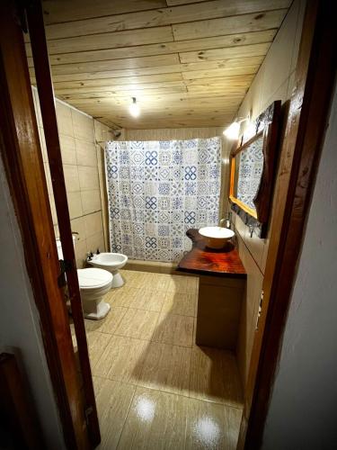 a small bathroom with two toilets and a sink at Tano in Villa Gesell
