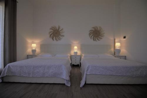 モルチャーノ・ディ・レウカにあるVilla Magnoliaのベッドルーム1室(ベッド2台、壁に鏡2つ付)