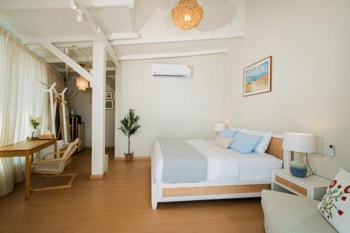 a white bedroom with a white bed and a desk at Sea Salt Stay Samui in Nathon