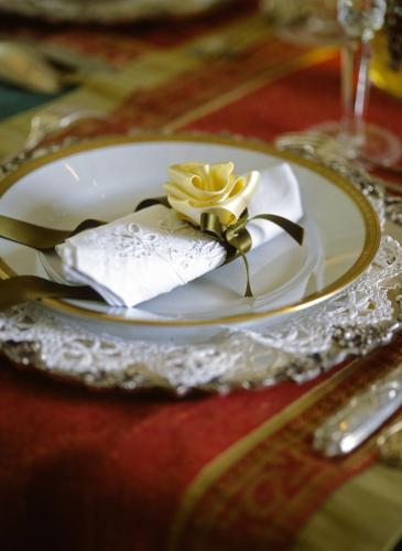 a white plate with a yellow flower on a table at Villa Althea in Mango