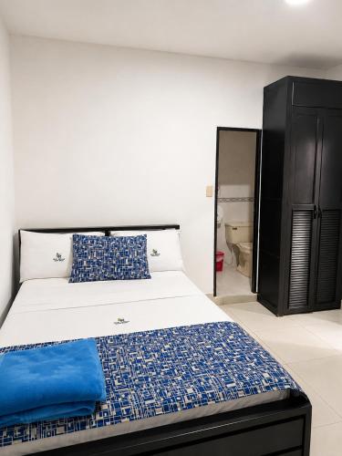 a bedroom with a large bed with blue and white sheets at Hotel Medellin in Santa Marta