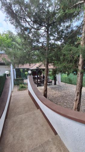a fence in a park with trees and benches at Palić Libero Apartman in Palić