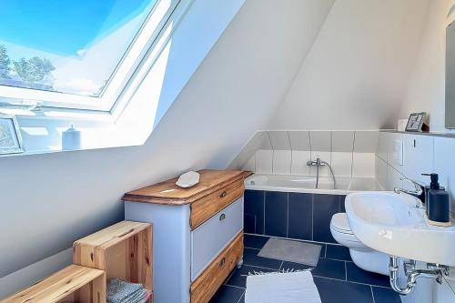 a bathroom with a sink and a toilet and a window at Gästehaus Maria Rast in Suderburg