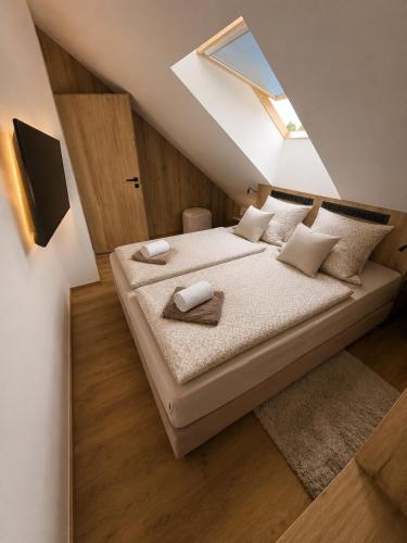 a bedroom with a large bed with a skylight at SNOW LAKE Lipno in Lipno nad Vltavou