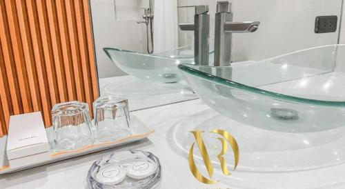 a bathroom with a sink and a counter with two mirrors at LAVERO SUITES in Kalibo