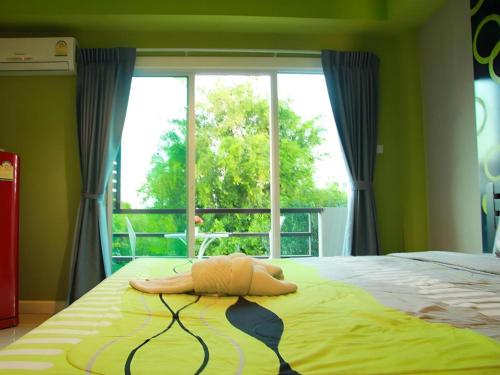 a woman laying on a bed in front of a window at RungRoj Panich Hotel in Ban Bang Saen (1)