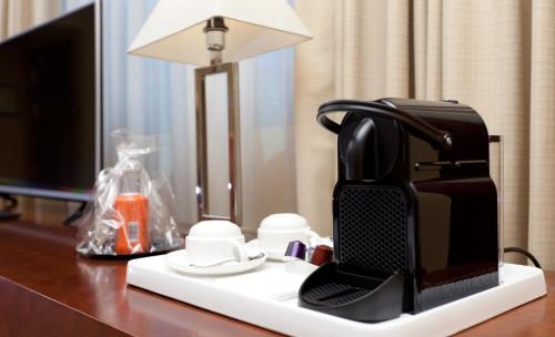 a coffee maker sitting on top of a table next to a lamp at Hotel Nuevo Madrid in Madrid