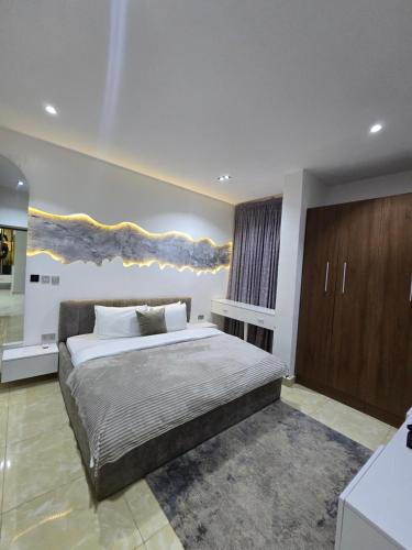 a bedroom with a large bed and wooden cabinets at Grey Ivy Apartment in Abuja