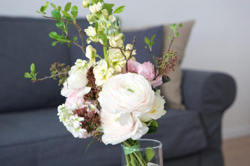a glass vase filled with white and pink flowers at Premium Class Apartments in Zagreb