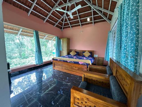 a bedroom with a bed and a window at Sun Side Cottages in Madikeri