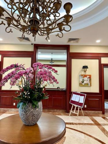 a vase of flowers on a table in a lobby at Diny Aparthotel - Rooftop Pool - The Manor 2 in Ho Chi Minh City