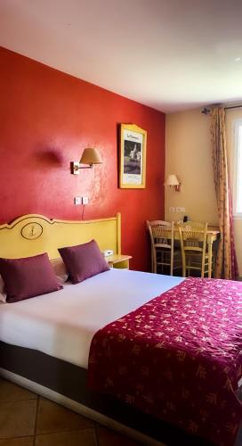 a hotel room with a large bed with red walls at LOGIS HOTEL & RESTAURANT L'ETAPE Bouc Bel Air - Gardanne in Bouc-Bel-Air