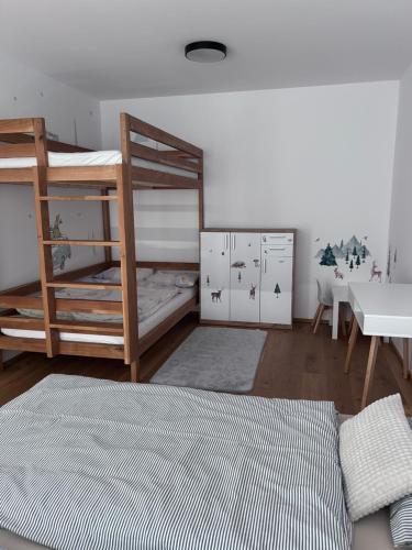 a bedroom with two bunk beds and a desk at Krkonoše - apartmán s výhledem in Benecko