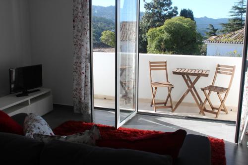 a living room with a couch and a balcony with a table and chairs at Cabriz White House in Sintra