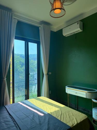 a bedroom with a bed and a large window at She Stay in Hòa Bình