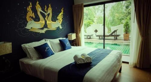a bedroom with a large bed and a large window at Maytara Hotel in Pattaya South