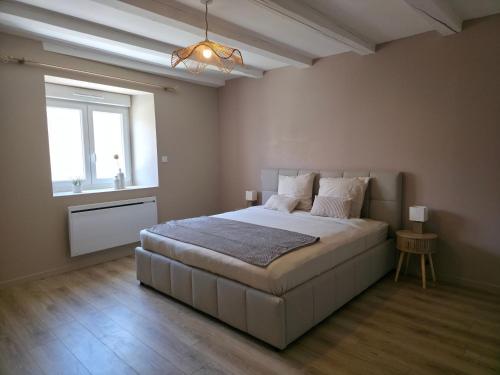 a bedroom with a large bed and a window at L'Escale Cosy avec Terasse in Noidans-lès-Vesoul