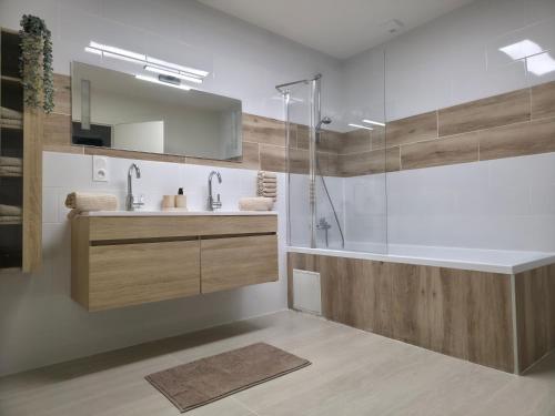 a bathroom with a tub and a sink and a shower at L'Escale Cosy avec Terasse in Noidans-lès-Vesoul