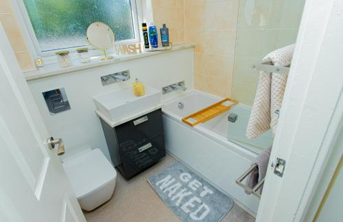 a bathroom with a sink and a tub and a toilet at The Cheshire ABode- Central Warrington- Stadium, Station Access- Sleeps 5 in Warrington