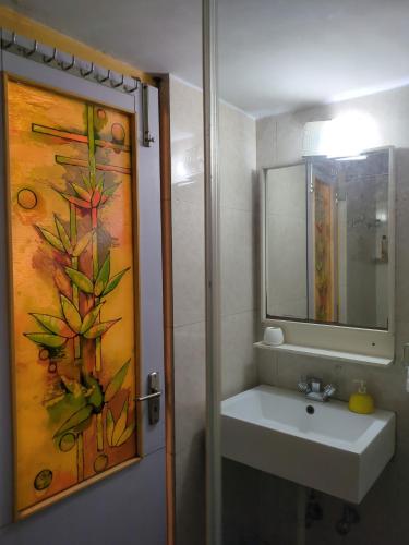a bathroom with a sink and a painting on the wall at Disharee 51A in Kolkata