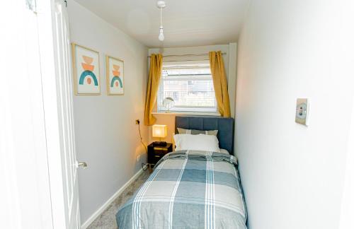 a small bedroom with a bed and a window at The Cheshire ABode- Central Warrington- Stadium, Station Access- Sleeps 5 in Warrington