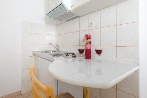 a kitchen with two wine glasses and a sink at Villa Tomasovic with pool in Podstrana in Podstrana