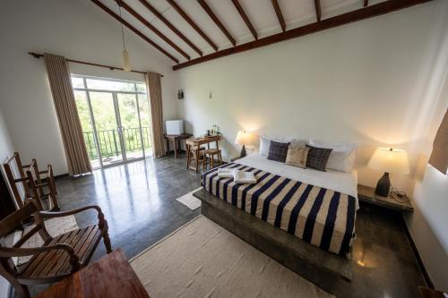 a bedroom with a bed and a table and chairs at Wild Wadi Wilpattu - Villas with private Plunge Pools in Ilavankulam